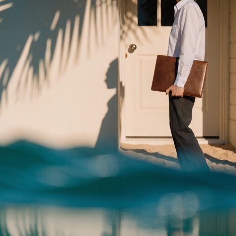 Notary arriving at a coastal home with a document folder